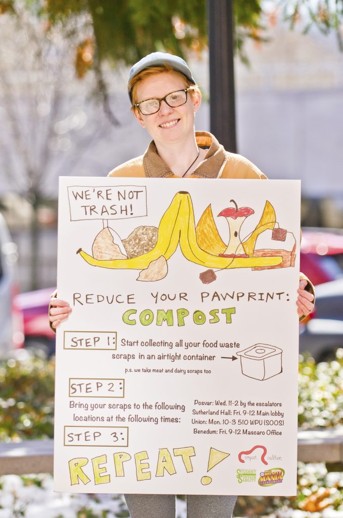 Student holds sign about how to compost