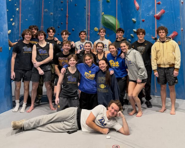 climbing club posing in front of a climbing wall