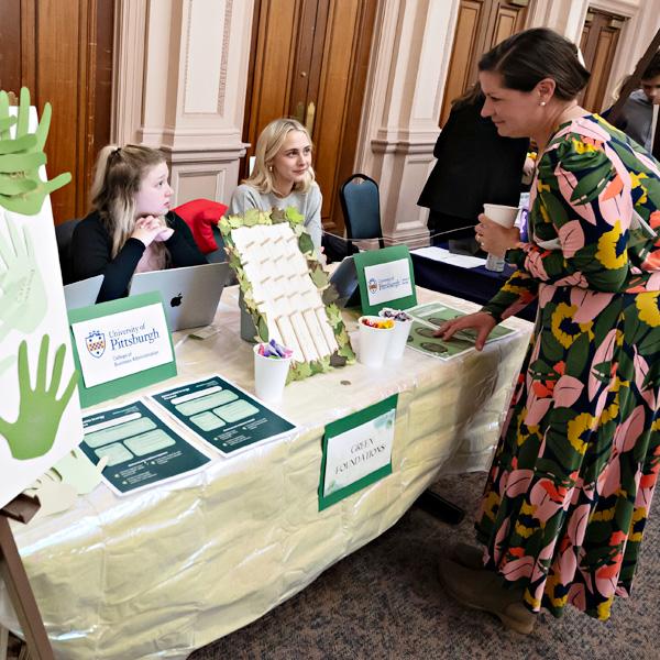Students work at a table promoting sustainable initiatives.
