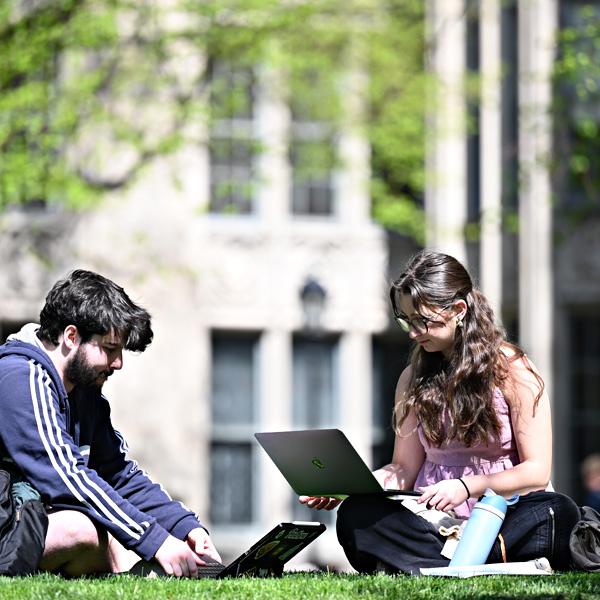 Students use technology on the Cathedral of Learning lawn.