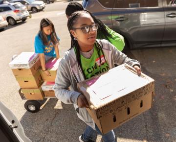 students carring boxes of food for those in need