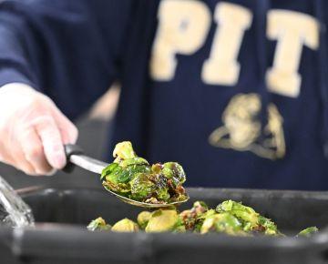 Hand holds a spoon with brussels sprouts
