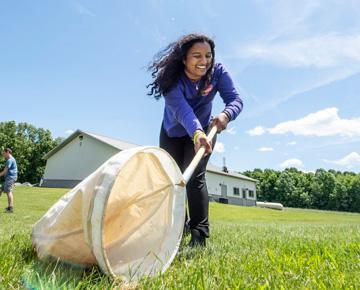 student in a field with net