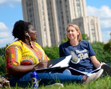 two students in front of the Cathedral of learning
