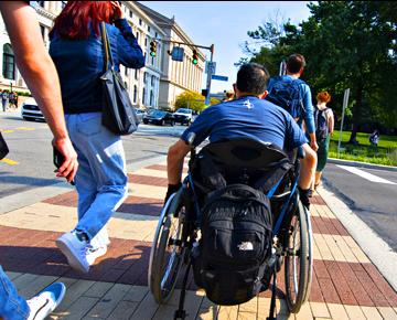 Person using a wheelchair crossing the street