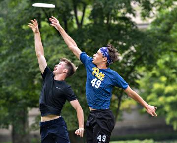 Two people catching a frisbee