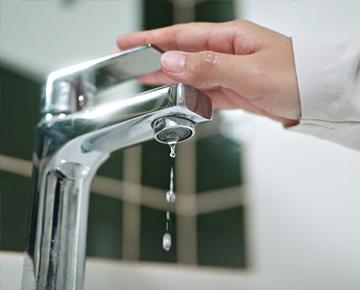 Hand turning off faucet