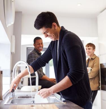 three guys laughing in a kitchen