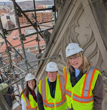 Heinz Chapel staff in workgear and hardhats in front of the Chapel